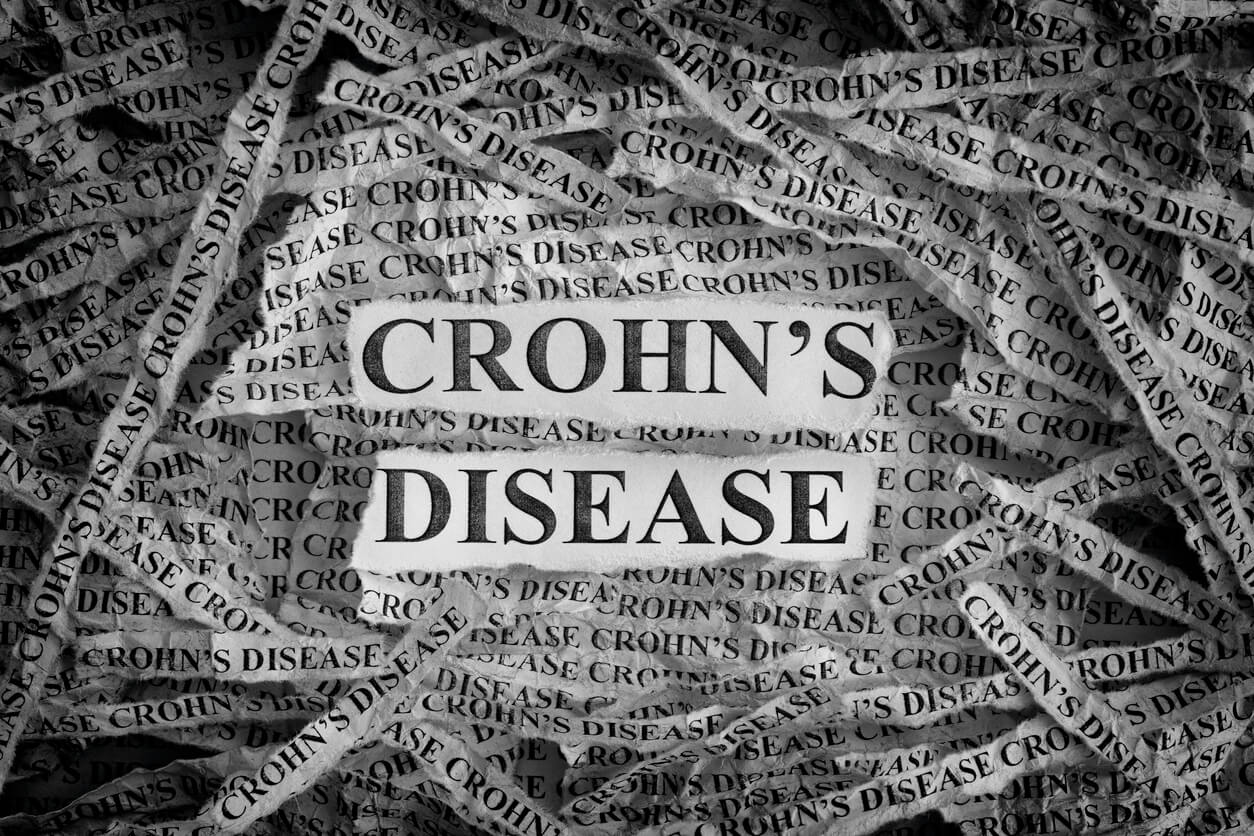 Torn pieces of paper with the words Crohn's Disease