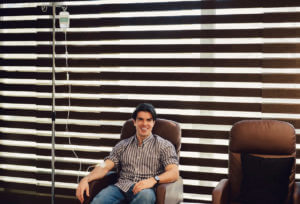 Man getting IV infusion therapy for his ulcerative colitis at a GI care center.