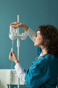 Middle Aged Caucasian Woman Nurse Preparing Intravenous Drip in Hospital.