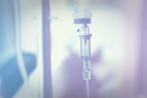 Close up IV saline solution drip for patient's IV infusion therapy in hospital.